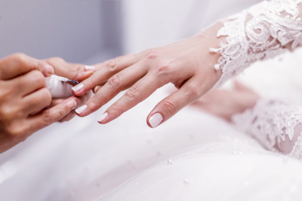 bride's nail polish being applied during wedding day makeover